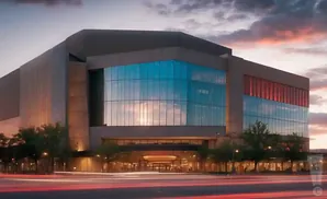 Modern building with glass windows reflecting the sunset sky, with blurred car lights in the foreground.