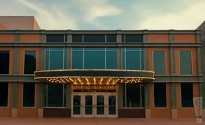 Exterior of a theater with a marquee and large windows.