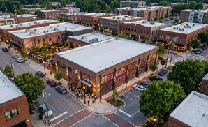 Aerial view of a brick building with colorful stained-glass windows and a crowd gathered outside.