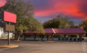 Empty roadside diner with a vibrant red and purple sunset sky.