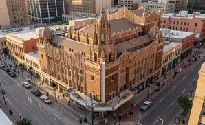Aerial view of an ornate, historic brick theatre with detailed architectural carvings, set within a city block.