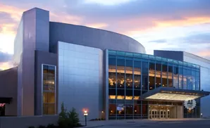 Modern building with glass facade and illuminated interior at dusk