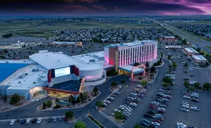 Aerial view of a casino and hotel complex at dusk with a purple sky.