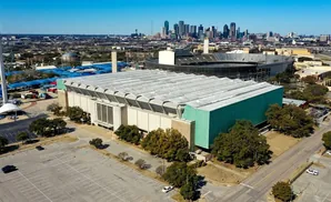 Aerial view of the Dallas Convention Center with the city skyline in the background.