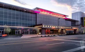 Modern entertainment complex with glass facade and illuminated pink and yellow accents.