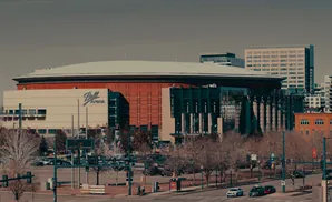 Ball Arena in Denver, with surrounding buildings and trees.