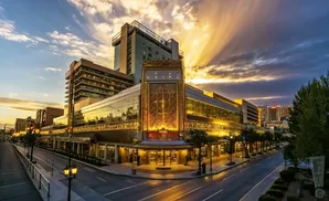 Golden hour sunset illuminates a grand building with a stylized gold facade and a tall tower.