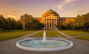 A fountain in front of a domed, classical building on a sunny day.