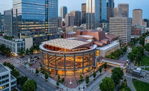 Aerial view of a modern city center with glass skyscrapers and a distinctive domed building.
