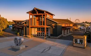 Modern building with a large wooden entryway and a contemporary sculpture in the foreground.