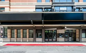 A red carpet leads to the entrance of a building with a black marquee and brick accents.