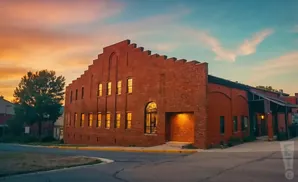 Red brick building with large windows at sunset.