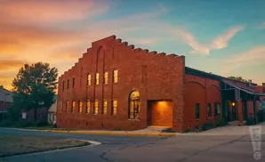 Brick building with a stepped roof at sunset.