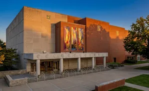 Modern brick and stone building with banners hanging above entrance.