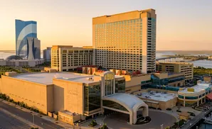 Resorts Casino Hotel in Atlantic City, NJ, bathed in golden hour light, with a tall blue skyscraper and casino complex.