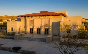 Building entrance at golden hour, with desert mountains in the background.