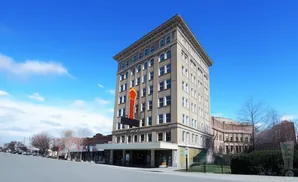Tall, vintage building with a marquee sign on a sunny day.