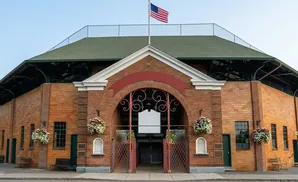 Brick building with arched entrance and American flag.