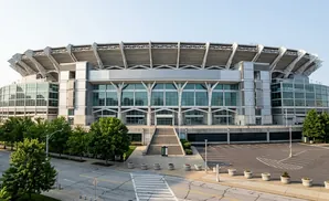 A stadium with large glass windows and seating under a metal roof.
