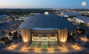 Aerial view of a domed stadium at dusk with a full moon in the sky.
