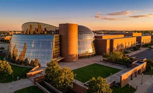 Aerial view of a modern building with glass and brick architecture at sunset.