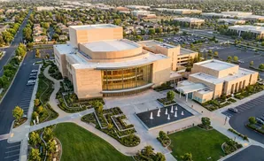 Aerial view of a modern building complex with fountains and landscaped gardens.