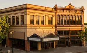 Marquee of an old theater on a brick building at sunset.