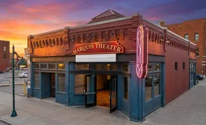 Marquis Theater at sunset, with red brick building and neon sign.