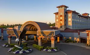 Large eagle statue with fish in front of a hotel with a large arched entrance.