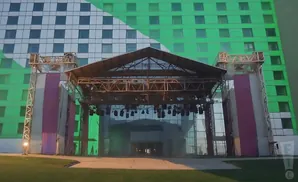 Outdoor stage setup with a building behind it, half white and half green.