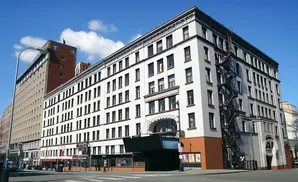A white building with a fire escape and a red brick building next to it.