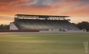 Empty stadium seating under a colorful sunset sky.