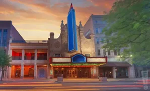 Marquee of an old theater at sunset with light streaks from passing cars.