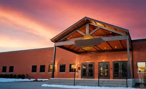 Exterior of a modern brick building with a covered entrance at sunset.