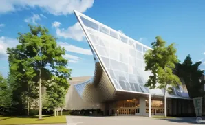 Modern glass-fronted building with sharp angles, surrounded by green trees under a blue sky.