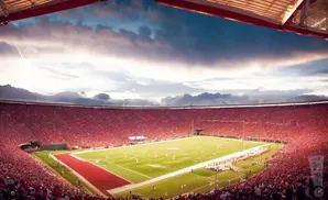 A football stadium packed with fans in red, under a dramatic sky.