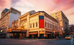 A historic theater with a marquis at sunset.