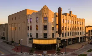 Art deco theater with a marquee and ornate facade bathed in warm sunset light.
