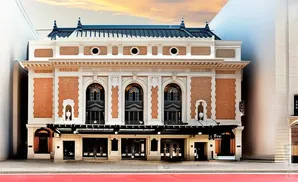 A grand theater facade with brick accents and arched windows under a twilight sky.