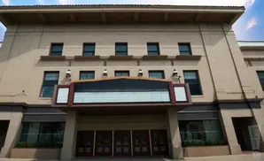 Exterior of a theater with a marquee and multiple doors.