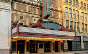 Exterior of a vintage theater with a marquee and ornate architectural details.