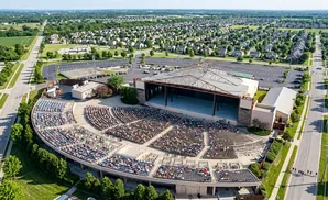 Aerial view of an outdoor amphitheater filled with people, with a stage and seating area.