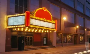 An illuminated marquee of a vintage theater at night.