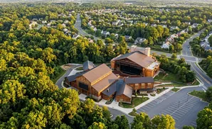 Aerial view of an outdoor amphitheater nestled among trees and residential houses.