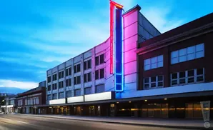 Art deco theater with red and blue neon lights at twilight.