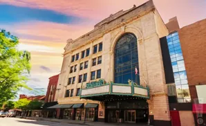 The Ohio Theatre with a marquee and an arched window, under a sunset sky.