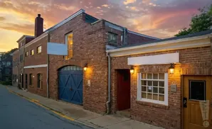Brick building with a blue garage door and warm lighting on a street at sunset.