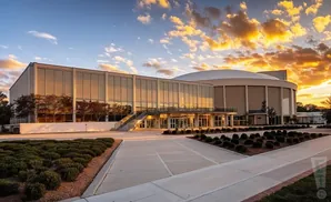 A modern building with large glass windows at sunset.