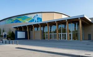 Modern building with large windows and a curved mural featuring stylized landscapes and a skier.
