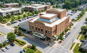 Aerial view of a brick theater building with a marquee, surrounded by parking lots and residential homes.